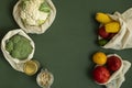 Vegetables in eco bag and nuts in a glass jar on green surface. Pepper, tomato, corn, cucumber, broccoli, cauliflower in Royalty Free Stock Photo