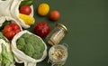 Vegetables in eco bag and nuts in a glass jar on green surface. Pepper, tomato, corn, cucumber, broccoli, cauliflower in Royalty Free Stock Photo