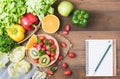 Vegetables and fruit with notebook on wood background Royalty Free Stock Photo