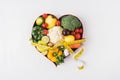 vegetables and fruits laying in heart shaped dish near stethoscope and measuring tape Royalty Free Stock Photo