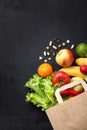 Vegetables and fruits in a paper bag on a white background with space for text. Vitamins on the table. Food delivery.