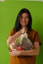 Vegetables and fruits. shopping bag in the hands of a woman on a green background. reasonable consumption, shopping concept.