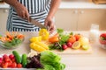 Vegetables and fruits such as mangos, lemons, bell peppers, tomatoes, carrots are prepared on the table