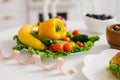 Vegetables and fruits for weight loss on a plate with a measuring tape in the kitchen Royalty Free Stock Photo