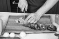 Vegetables getting cut on wooden cutting board. Hand slice green salad with ceramic knife. Hands cut vegetables with