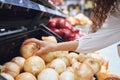 Vegetables, grocery shopping and health while a customer choose fresh onions in supermarket or greengrocer store. Close Royalty Free Stock Photo