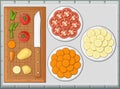 Vegetables, knife, sliced potato, carrot in pieces and tomatoes on a cutting board