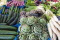 Vegetables on market, fresh artichokes, radishes, cucumbers, leek on market stable