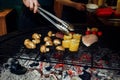 Vegetables and meat grilling. hand with tongs and mushrooms corn Royalty Free Stock Photo