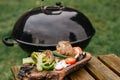 Vegetables near the grill. Green grilling. Preparing to cook healthy vegan food on fire. Fresh artichoke, tomato, pepper and