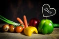 Vegetables on a old wooden table with a heart with word diet