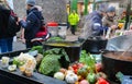 Vegetables piled up around cast iron cooking pots full of steaming soup as customers stand around at famous Boroughs Market next t