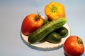 Vegetables in a plate on a gray background.