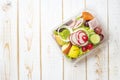 Vegetables salad in plastic bowl on white wood table Royalty Free Stock Photo