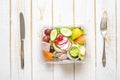 Vegetables salad in plastic bowl on white wood table Royalty Free Stock Photo