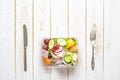 Vegetables salad in plastic bowl on white wood table Royalty Free Stock Photo