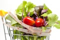 Vegetables in the shopping cart with measuring tape on white background Royalty Free Stock Photo