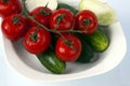 vegetables sprinkled with water lying on a plate: tomato, cucumber, onion