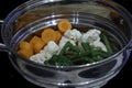 Vegetables in a stainless steel steamer prepared to be cooked