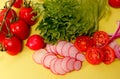 Vegetables such as radish, tomato and lettuce on yellow background