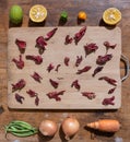 Vegetables sunny composition with hibiscus flowers, lime, onion, carrot and green beans