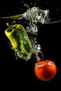 Vegetables tomato and paprika in water splash on black Royalty Free Stock Photo