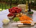 Vegetables, tomatoes, onions, chopped celery, carrot and basil leaves on the table with bottles of olive oil and balsamico vinegar Royalty Free Stock Photo