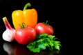 Vegetables. Tomatoes, sweet peppers, garlic and a sprig of parsley on a black background. Royalty Free Stock Photo