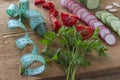 Vegetables on an uncouth board. Measuring tape. Low calorie diet concept