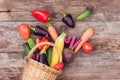 Vegetables in a wicker basket on a wooden background. Fresh crops, farm products, a vegetable garden at home. Copy space