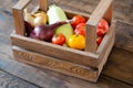 Vegetables in wooden crate. Tomatoes, onions, squash