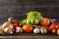 Vegetables, zucchini, tomato, bell pepper, garlic, mushrooms, onions, lettuce leaves on a wooden background Royalty Free Stock Photo
