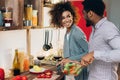 Vegetarian african-american couple cooking salad in kitchen