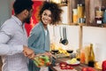 Vegetarian african-american couple cooking salad in kitchen Royalty Free Stock Photo