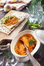 Vegetarian appetizer. Carrot dip on dry bread, sesame dressing and olive oil