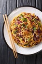 Vegetarian Asian egg noodle salad with seasonal vegetables close-up in a plate. Vertical top view Royalty Free Stock Photo