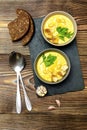 Vegetarian autumn pumpkin traditional soup with seeds, creamy silky texture, cilantro parsley dill greens, croutons, bread, garlic