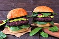 Vegetarian beet burgers with avocado and spinach against dark wood Royalty Free Stock Photo