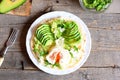 Vegetarian breakfast with a poached egg, avocado slices, chinese cabbage, lettuce, tortilla, sauce and spices