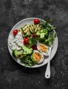 Vegetarian breakfast, snack bowl - salad mixed vegetables, boiled egg, grilled zucchini, cheese on a  dark background, top  view Royalty Free Stock Photo