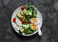 Vegetarian breakfast, snack bowl - salad mixed vegetables, boiled egg, grilled zucchini, cheese on a  dark background, top  view Royalty Free Stock Photo