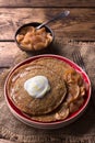 Vegetarian buckwheat pancakes with baked apples with cinnamon, honey and fresh cream on a wooden table Royalty Free Stock Photo