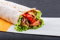 Vegetarian Burrito wraps from grilled vegetables and lettuce on dark wooden background. Healthy lunch. Royalty Free Stock Photo