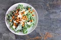 Vegetarian plant based Caesar salad with chickpeas, kale and a yogurt dressing. Top down view on a slate background.