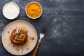 Vegetarian chocolate pancakes with nuts, maple syrup, fruit, mango jam, sour cream on gray background, copy space, top view Royalty Free Stock Photo