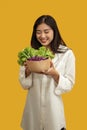 Vegetarian concept, Healthy woman eating mix fresh vegetable salad on isolated yellow background Royalty Free Stock Photo