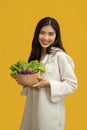 Vegetarian concept, Healthy woman eating mix fresh vegetable salad on isolated yellow background Royalty Free Stock Photo