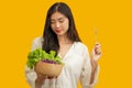 Vegetarian concept, Healthy woman eating mix fresh vegetable salad on isolated yellow background Royalty Free Stock Photo