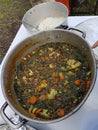 Vegetarian cooking in the wild, Stew of lentils and vegetables in a big put outside Royalty Free Stock Photo