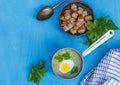 Vegetarian cream of wild greens soup in a ladle and a copper bowl with crackers on a blue background Royalty Free Stock Photo